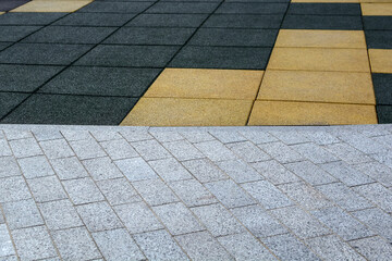 Fototapeta premium Paving slabs and soft surfaces for playgrounds, construction of paths, roads or sidewalks. Abstract combined background, pavement texture