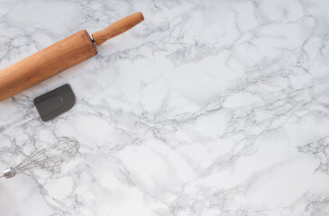 Cooking tools on a marble counter with space for lettering