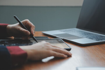 Asian Businesswoman Using laptop computer and working at office with calculator document on desk, doing planning analyzing the financial report, business plan investment, finance analysis concept.