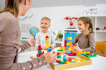 Kindergarten children playing with colorful building blocks. Healthy learning environment. Learning...