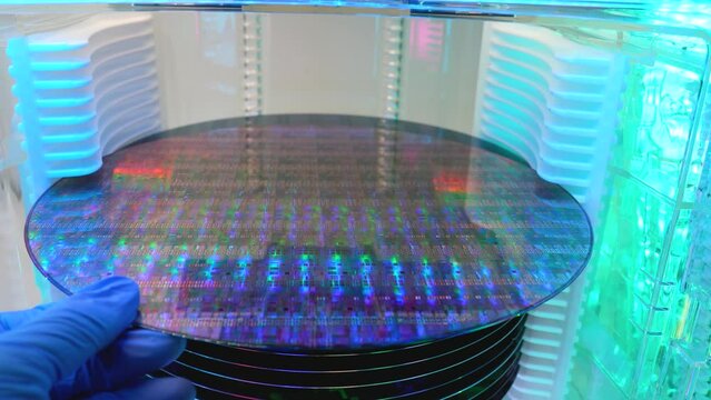 Gloved Hand Holding a Silicon Wafer in plastic holder box