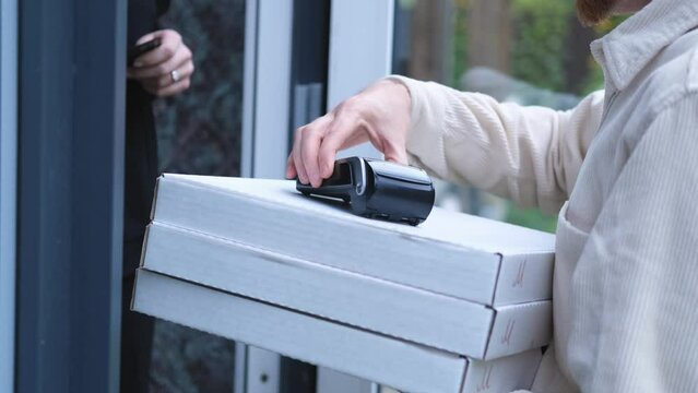 close-up the delivery man brought pizza and a payment terminal