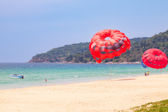 beautiful bright karon beach in thailand on phuket island with clear turquoise water in the sea, white sand with umbrella and blue sky. A popular tourist place in the hot countries of Asia.