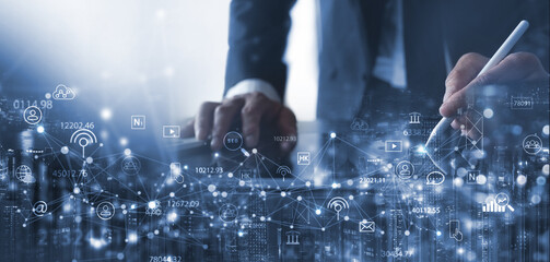 Digital marketing, IoT Internet of Things, Internet communication technology, business plan and strategy concept. Businessman using digital tablet with market research and smart communication icons