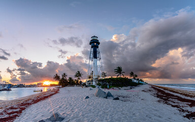lighthouse on beach with sunset