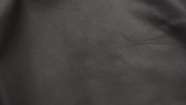 Slow motion handheld shot of soft gray brown leather closeup