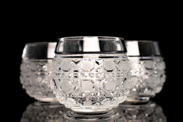 Three crystal glasses, macro, isolated on black background.