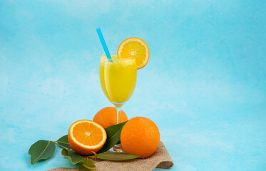 Orange juice isolated on light blue background, Fresh and healthy juice with sliced orange fruits on the background and copy space for text