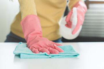 Cleanliness, asian young woman working chore clean up on white table, hand wearing gloves using rag rub remove dust with spray bottle. Household hygiene clean up, cleaner, equipment tool for cleaning.