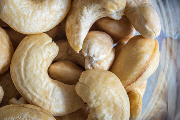 Peeled cashew nuts inside glass jar closeup