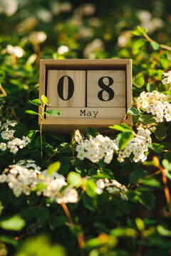 Wooden blocks with the 8 May calendar date amongst flowers