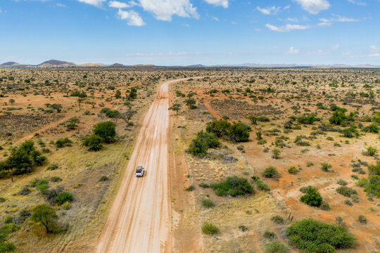 Drone image of off road vehicle driving on dirt road in Africa bush