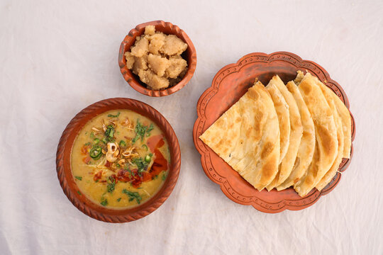 Desi breakfast, haleem, halim, dhaleem, halwa and paratha served in dish isolated on background top view of bangladesi breakfast