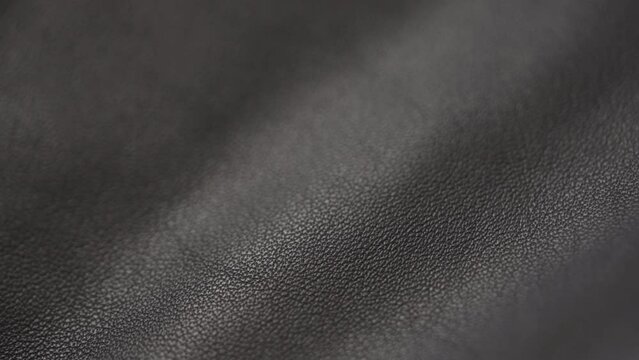 Slow motion handheld shot of soft gray brown leather closeup