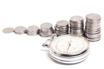 Time is money. Stopwatch and stacks of coins