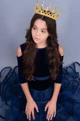 Little queen wearing golden crown. Teenage girl princess holding crown tiara. Prom party, childhood concept. © Olena