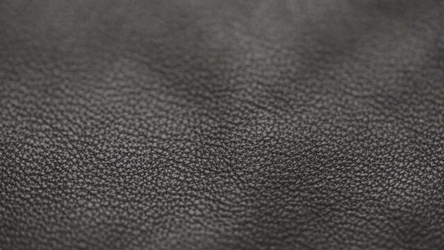 Slow motion handheld shot of soft gray brown leather closeup