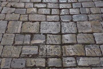 Stone pavement texture. Granite cobblestoned pavement background. Abstract background of old cobblestone pavement close-up. ..