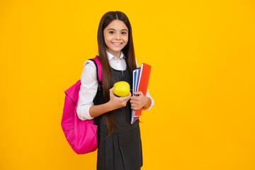 Schoolchild, teenage student girl with school bag backpack hold aplle and books on yellow isolated studio background. Children school and education concept.