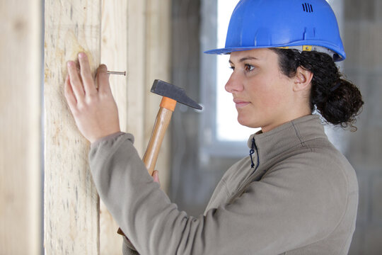 woman builder hammering a wall
