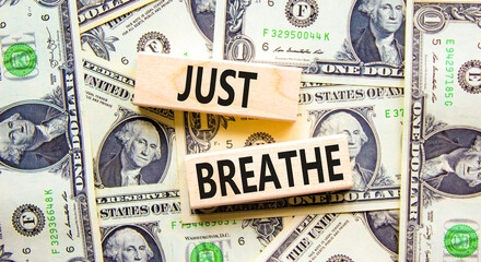 Just breathe and psychological symbol. Concept words Just breathe on beautiful wooden block. Beautiful background from dollar bills. Business psychological and Just breathe concept. Copy space