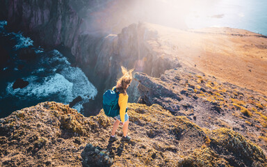 Top angle view of a backpacker woman walking down from the windy  foothills of an island in the...