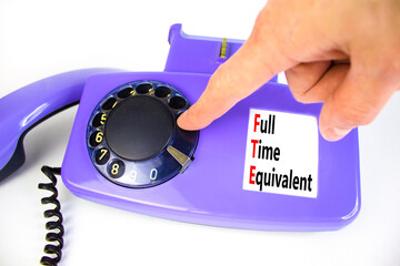 FTE Full time equivalent symbol. Concept words FTE Full time equivalent on beautiful old disk phone. Beautiful white table white background. Business and FTE Full time equivalent concept. Copy space.