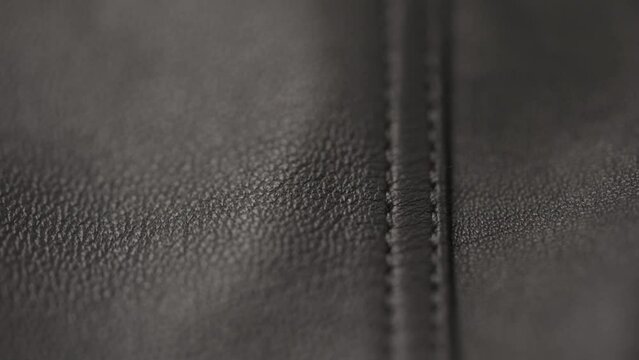 Slow motion closeup slide shot of soft gray brown leather