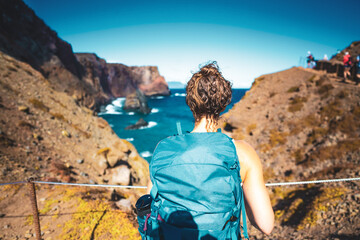 Tourist enjoys view on the north coast of Madeira Island in the Atlantic Ocean from a hiking trail....