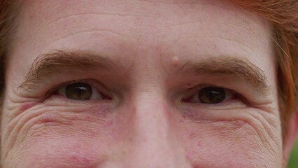 Man with happy emotion macro close-up eyes. A male person wide smile looking at camera feeling joy and contentment