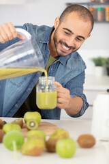 man pouring healthy juice made from kiwis