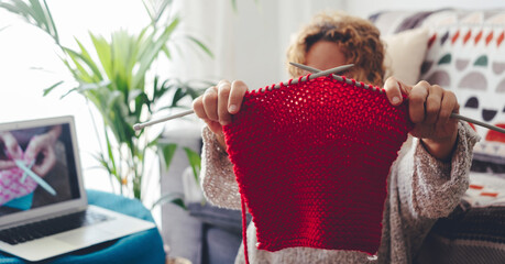 Online tutorial for handmade work at home in indoor hobby leisure activity. Woman in knitting work...