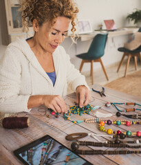 Alternative new business job at home concept. One woman doing jewels and accessories using colorful...
