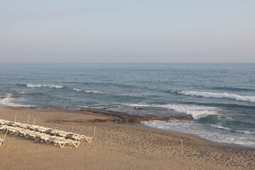 On the beach there are umbrellas and sunbeds. Summer vacation. Beach season.