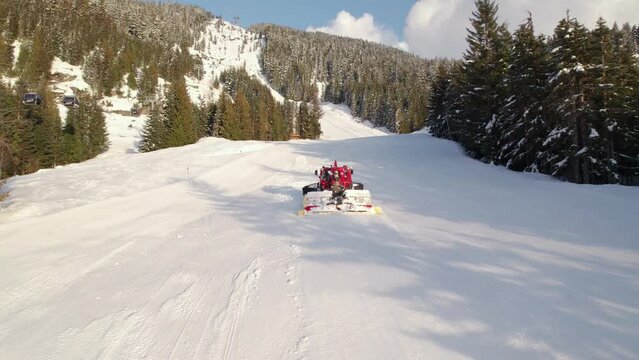 Snow grooming machine, snow maker, mountain sunset, snow, high alpine, snowy peak. 4K 24FPS.