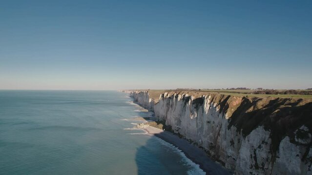 Aerial of impressive Normandy's white cliffs, round pebbles beaches and green pasture on the Alabaster Coast, France, 4K drone