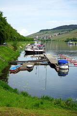 Titel: Hausboot, Boote und Yachten im Sommer im Yachthafen an der Mosel zwischen Weinbergen in...