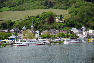 Ausflugsschiffe im Frühling bei Sonnenschein am Ufer der Mosel mit der Villa Sonora im Hintergrund...