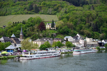 Ausflugsschiffe im Frühling bei Sonnenschein am Ufer der Mosel mit der Villa Sonora im Hintergrund...