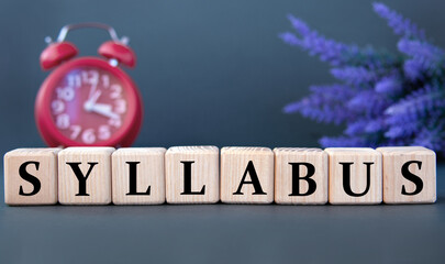SYLLABUS - word on wooden cubes on a gray background with an alarm clock and a branch of lavender