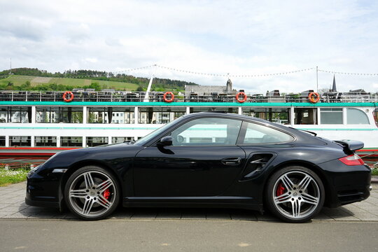 Porsche 911 Turbo oder Porsche 997 in Schwarz  im Fr&uuml;hling bei Sonnenschein am 07.05.2023 am Ufer der Mosel in Traben-Trarbach im Kreis Bernkastel-Wittlich in Rheinland-Pfalz in Deutschland