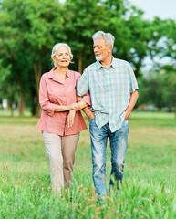 woman man senior couple happy retirement together elderly active love vitality bonding park outdoor walking holding hands leisure park fun smiling old