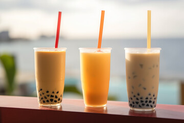 Bubble Tea glasses, Set of three drinking glasses of bubble tea with straws on beach background