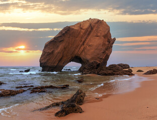 Sandy beach Praia de Santa Cruz with rock formation (Portugal). Misty weather. - obrazy, fototapety, plakaty