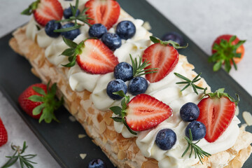 Strawberry meringue pavlova roll with cream and fresh seasonal berries