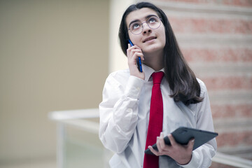 businesswoman talking by phone in office, working with tablet
