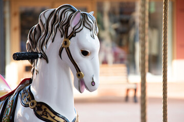 Fototapeta na wymiar children's carousel in the park of attraction. Horses on a carousel.Vintage french carousel horse closeup in fair park. Merry-go-round horses