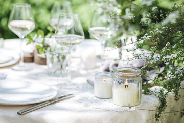 Romantic elegant luxury wedding table decor with white fresh spring blooming cherry apple tree flowers. Glass, candles, floral decoration for special marriage holiday event. No plastic zero waste