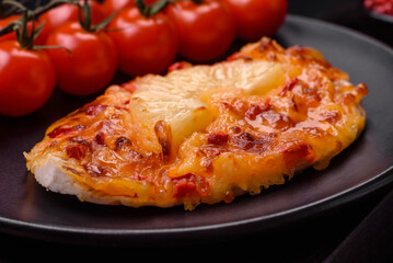 Grilled chicken fillet in the form of a steak with tomatoes, pineapple and cheese