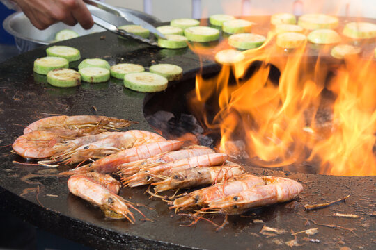 The process of cooking shrimp on a brazier. Open fire. Close-up.